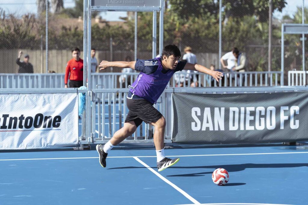a person in a purple jersey playing football on a blue court