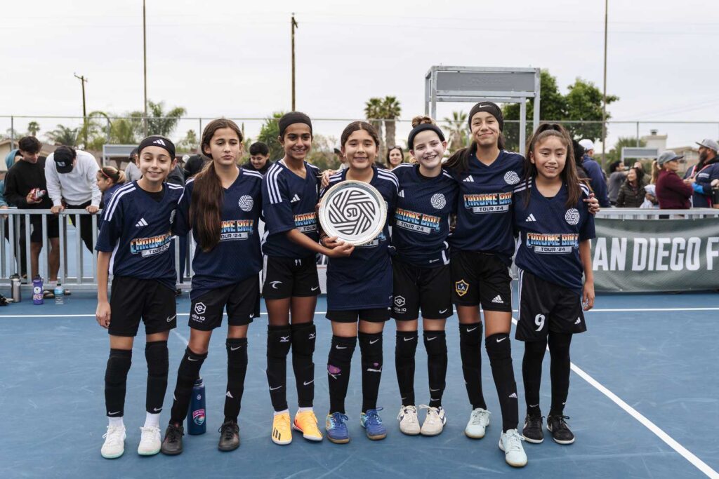 group of girls posing for a photo with a trophy