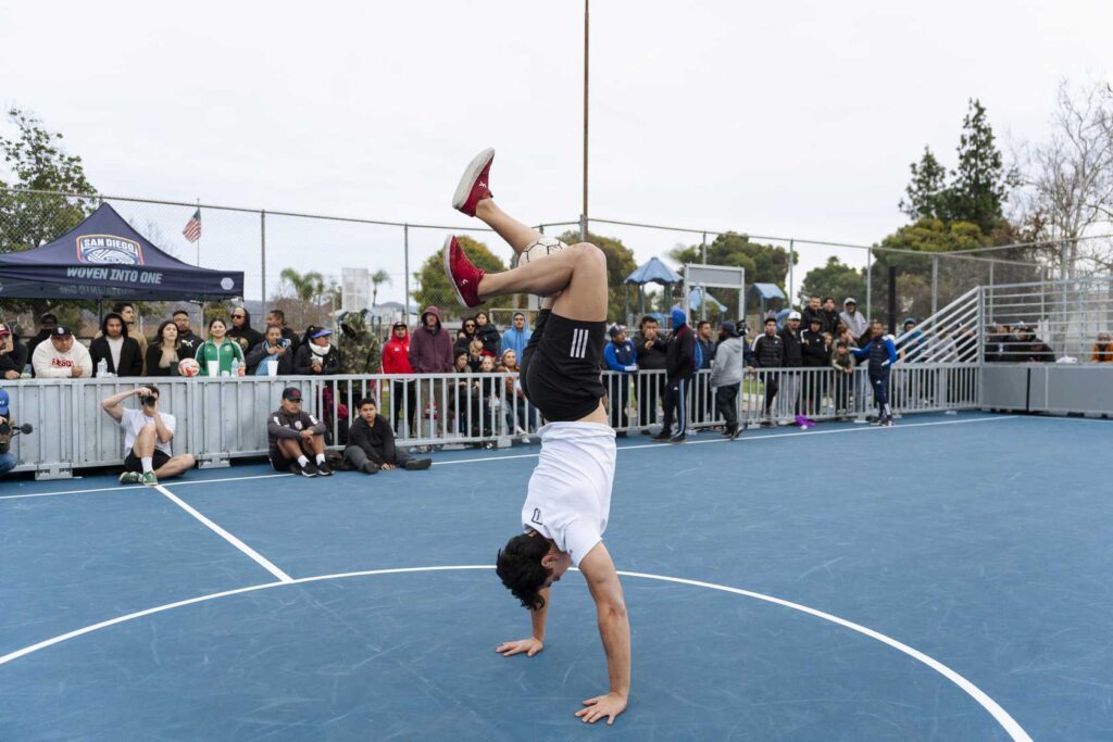 a person doing a handstand on a blue court